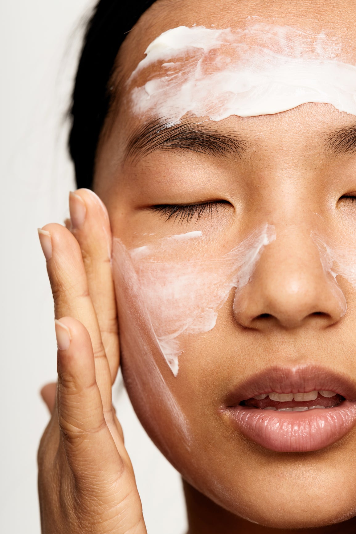 Woman slathering cream on her face